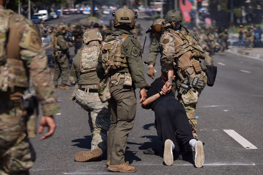 Police detain a man during a protest in Paramount, Calif., Saturday, June 7, 2025, after federal immigration authorities conducted operations.AP Photo/Eric Thayer