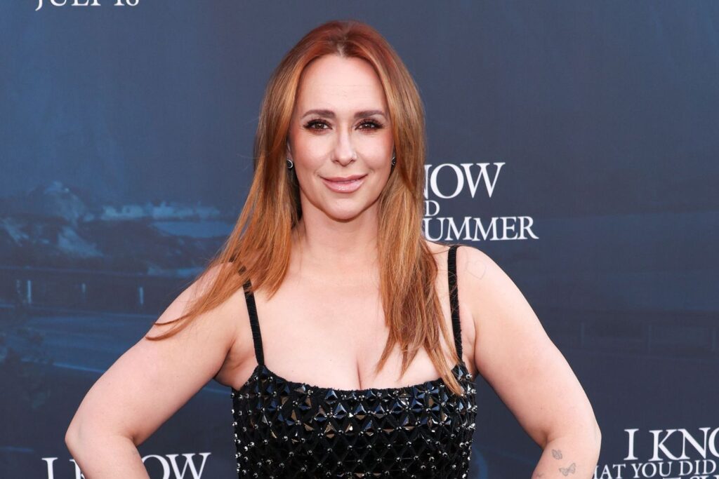 Jennifer Love Hewitt posing in a black sequined dress at a movie premiere event.